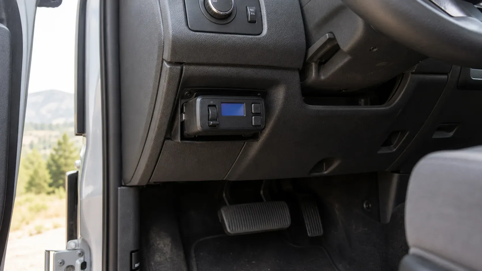Aftermarket proportional trailer brake controller mounted below a pickup dashboard