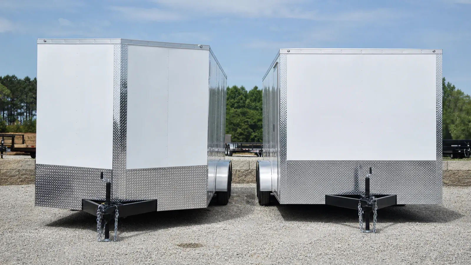 V-nose and flat-front enclosed cargo trailers shown side by side
